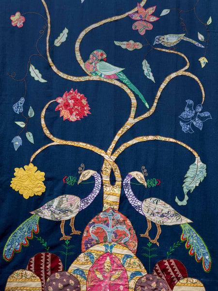 Embroidered design of peacocks and flowers on a blue background