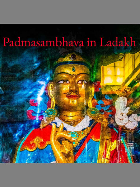 A colorful photograph of a golden statue with red, blue, and white details, overlaid with the red text 'Padmasambhava in Ladakh' at the top. The photo is framed with gray bars at the top and bottom.