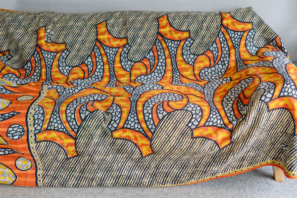 Textile with orange and gray abstract pattern on a wooden surface