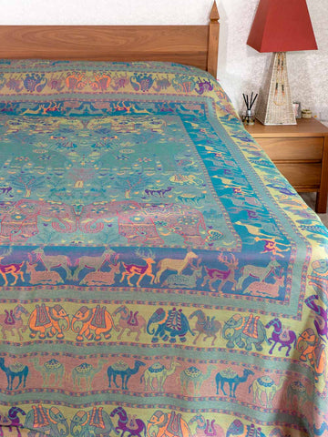Colorful bedspread with animal patterns on a bed in a bedroom setting.