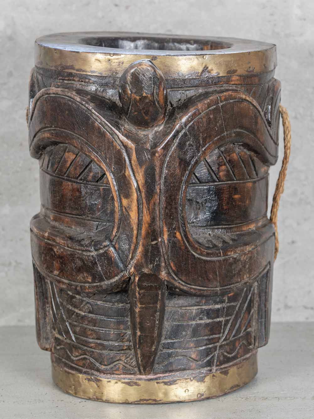 Decorative wooden vase with intricate carvings on a neutral background