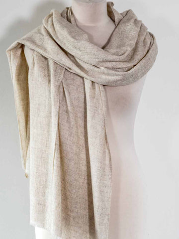 Beige scarf draped around a mannequin on a plain background