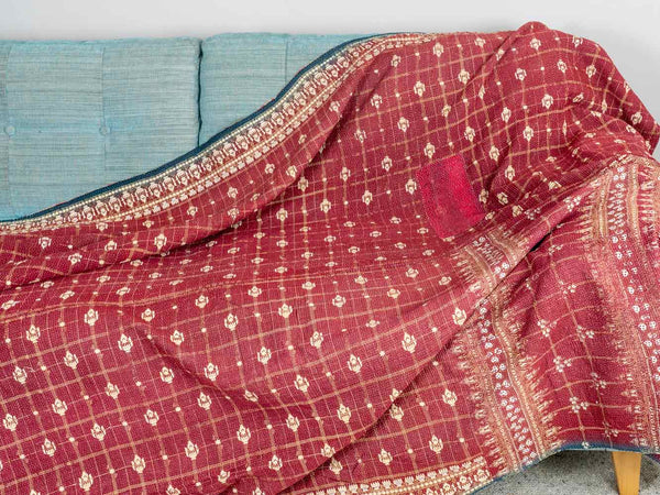 Red patterned fabric draped over a blue cushioned chair