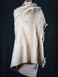 Beige shawl with intricate patterns and tassels on a black background