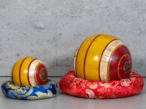 Two red & yellow decorative wooden balls