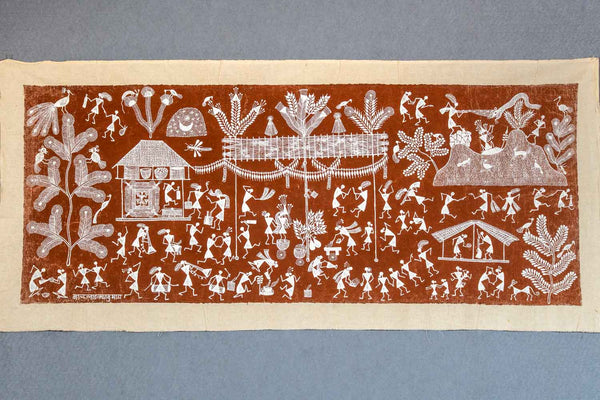 Traditional textile with white patterns on a brown background, featuring various figures and symbols.