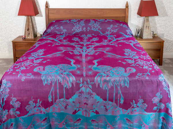 Bed with pink and blue floral patterned bedspread