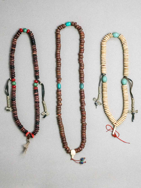 Three long beaded Tibetan prayer beads; brown, white & red beads with silver-toned counters.