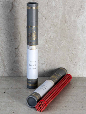 Tibetan herbal incense in a cylindrical packaging on a textured surface