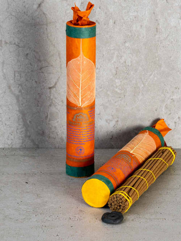 Nirvana Tibetan Incense in orange paper tube with a peepal leaf