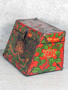 Decorative box with red and green floral patterns on a light gray background