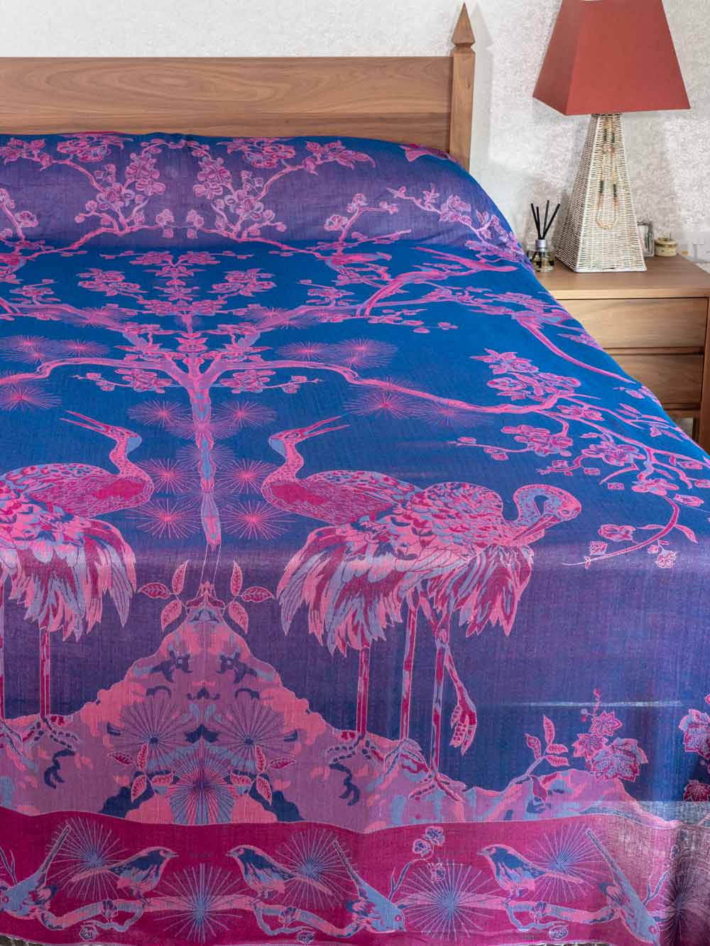 Bedspread with pink flamingo design on a blue background