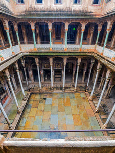 Historical stone courtyard with columns and colorful tiles