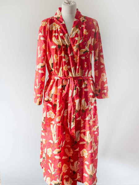 Red robe with floral pattern on a mannequin against a white background