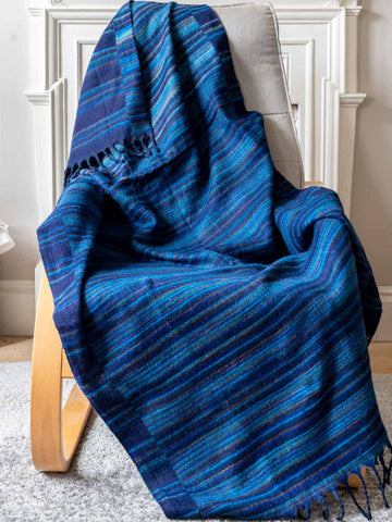 Blue striped blanket draped over a chair in a room with a white door.