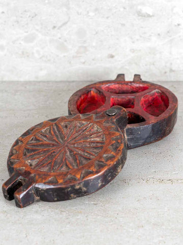 Decorative metal object with red interior on a textured surface
