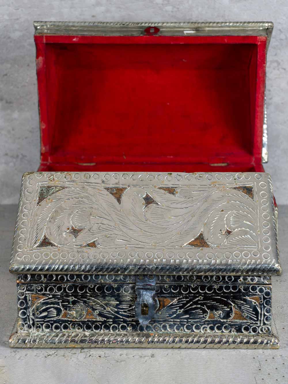 Decorative silver box with red interior on a gray background
