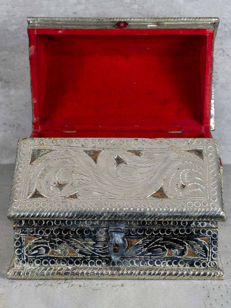Decorative silver box with red interior on a gray background