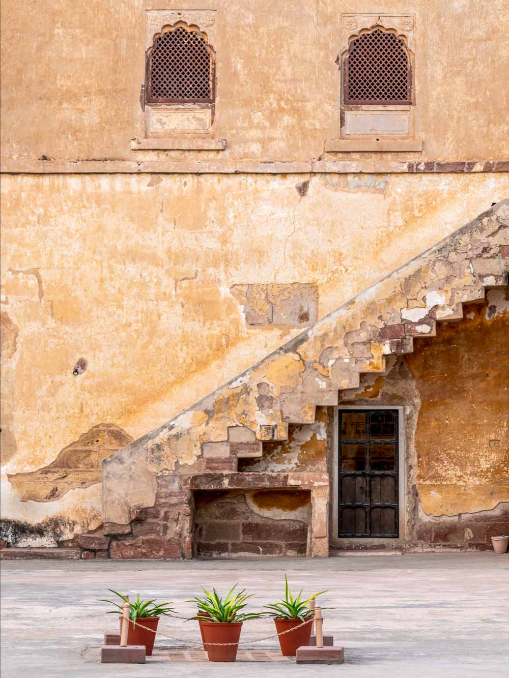 Staircase leading to a door with decorative elements on a beige wall.