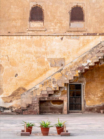 Staircase leading to a door with decorative elements on a beige wall.