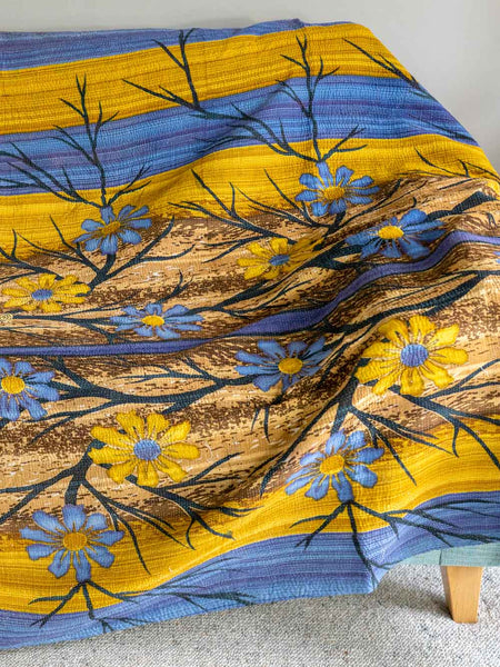 Floral patterned fabric with blue and yellow flowers on a wooden surface